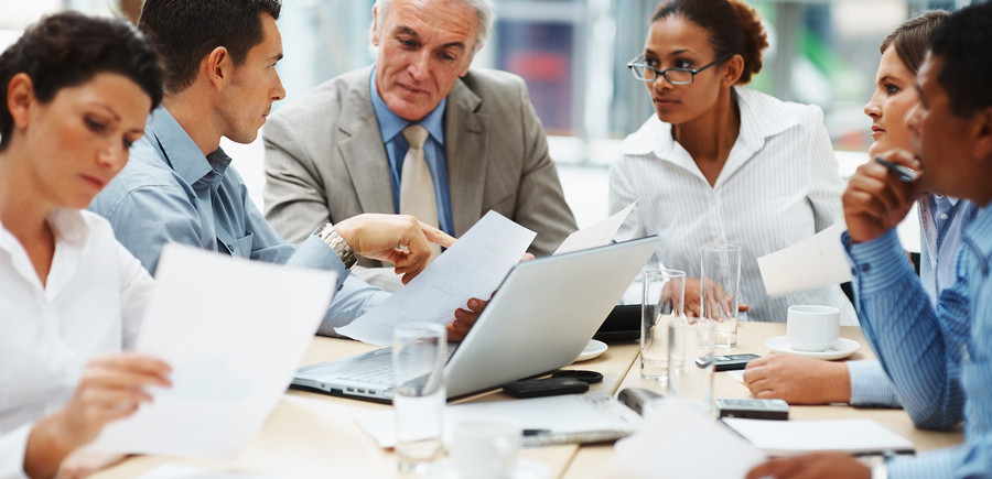 Business people discussing work on laptop at a meeting